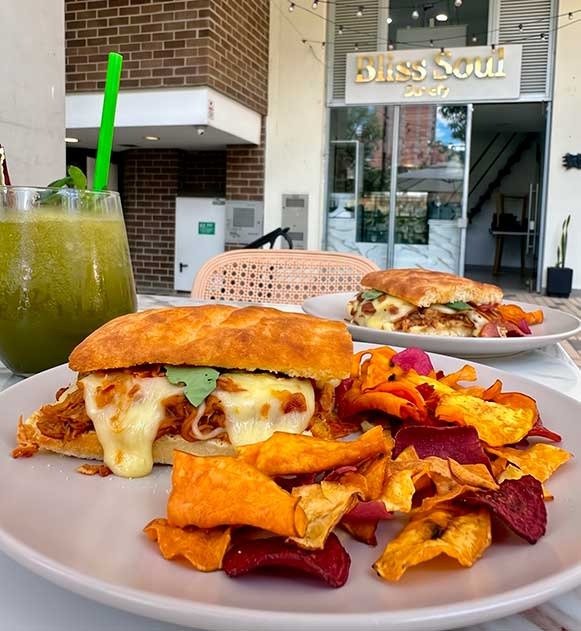 Sándwich artesanal de morrillo estofado sobre focaccia en mesa al aire libre